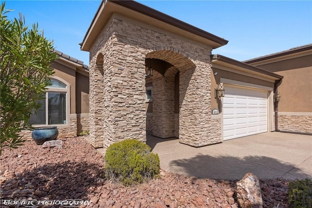 653 Paloma Cir, Mesquite, NV 89027 - view of side of property featuring concrete driveway, stone siding, stucco siding, and a garage