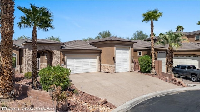 653 Paloma Cir, Mesquite, NV 89027 - view of front of property with stone siding, driveway, a garage, stucco siding, and a tiled roof