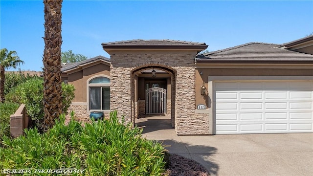 653 Paloma Cir, Mesquite, NV 89027 - view of front of house with an attached garage, stone siding, a tile roof, concrete driveway, and stucco siding