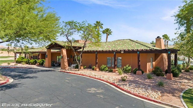 653 Paloma Cir, Mesquite, NV 89027 - view of front of home with a tiled roof, stucco siding, and a chimney