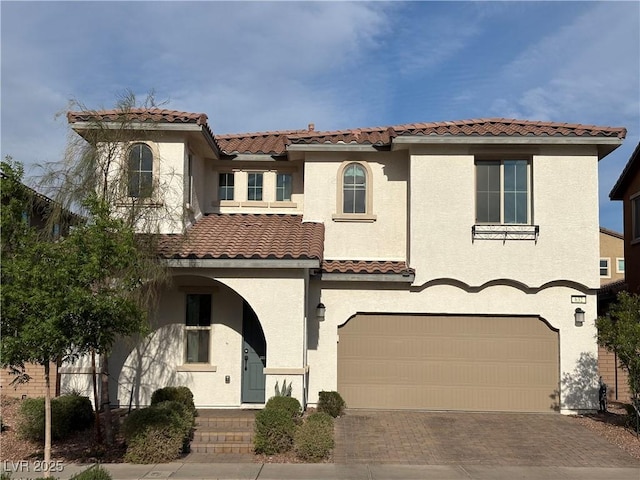 632 Cadence Vista Dr, Henderson, NV 89011 - mediterranean / spanish house with an attached garage, stucco siding, a tile roof, and decorative driveway