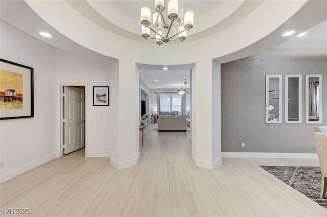 corridor featuring light wood finished floors, a chandelier, and recessed lighting