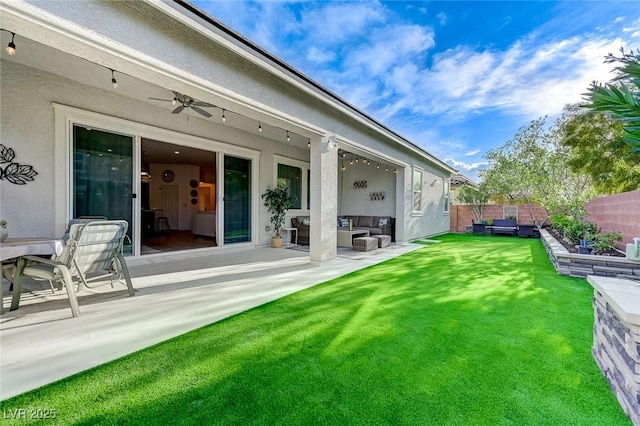 rear view of property featuring a lawn, ceiling fan, a fenced backyard, an outdoor hangout area, and a patio area