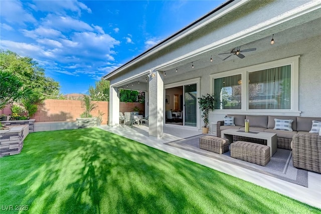 back of property featuring outdoor lounge area, stucco siding, fence, a yard, and a patio area