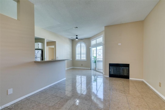 3150 Soft Breezes Dr Unit 2030, Las Vegas, NV 89128 - unfurnished living room with a ceiling fan, tile patterned floors, a textured ceiling, visible vents, and a glass covered fireplace