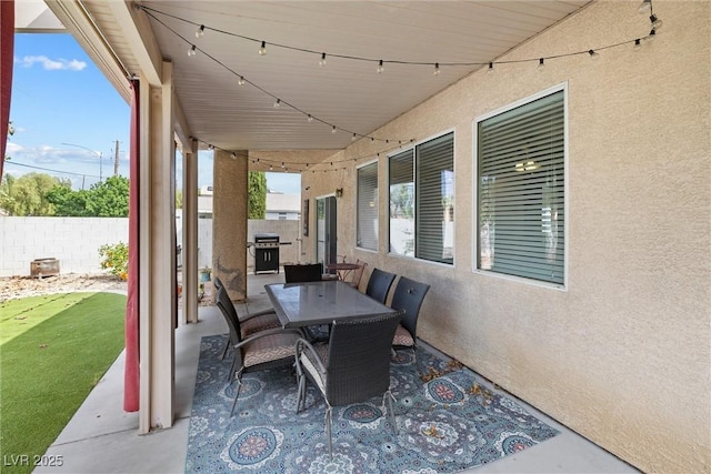 view of patio with a grill, outdoor dining space, and fence