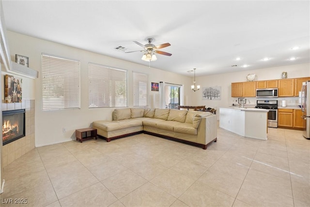 living area with visible vents, recessed lighting, ceiling fan, light tile patterned floors, and a tiled fireplace
