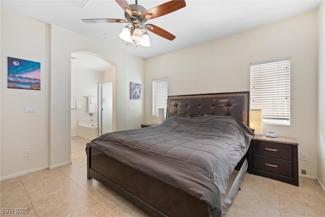 bedroom with arched walkways, baseboards, light tile patterned floors, and a ceiling fan