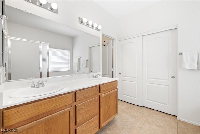 bathroom with a sink, tile patterned flooring, double vanity, and a shower stall