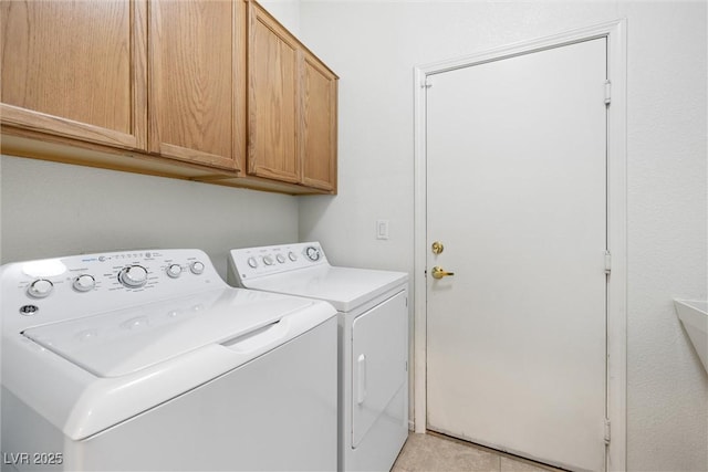 washroom with cabinet space, light tile patterned floors, and washer and dryer