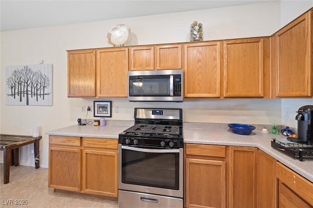 kitchen featuring light countertops, light tile patterned floors, and appliances with stainless steel finishes