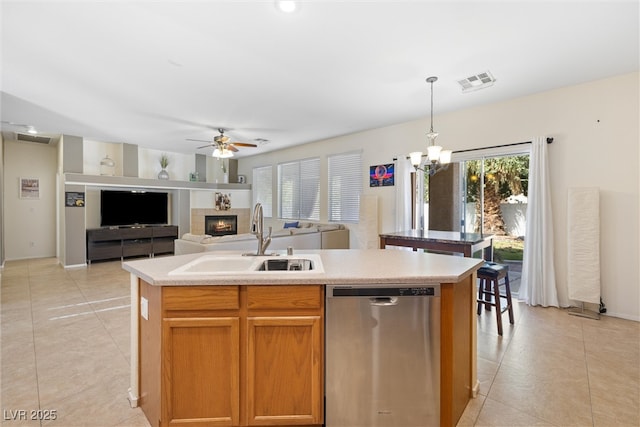kitchen with a sink, ceiling fan with notable chandelier, visible vents, dishwasher, and an island with sink