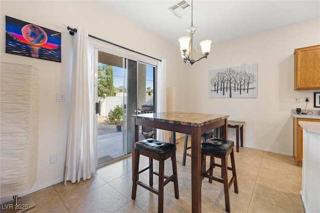 dining area with a chandelier, baseboards, light tile patterned floors, and visible vents