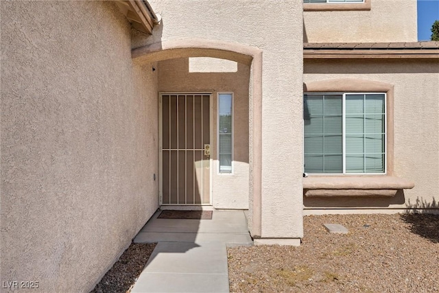 view of exterior entry with stucco siding