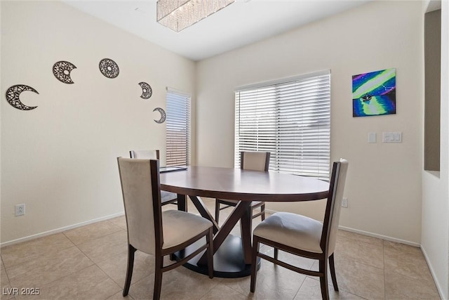 dining space with baseboards and light tile patterned floors