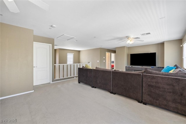 living room featuring attic access, baseboards, ceiling fan, visible vents, and light carpet