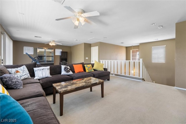 living room featuring ceiling fan, light colored carpet, and visible vents