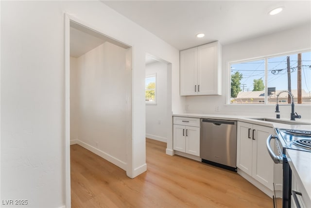 kitchen featuring a sink, range with electric cooktop, white cabinets, dishwasher, and light wood-style floors