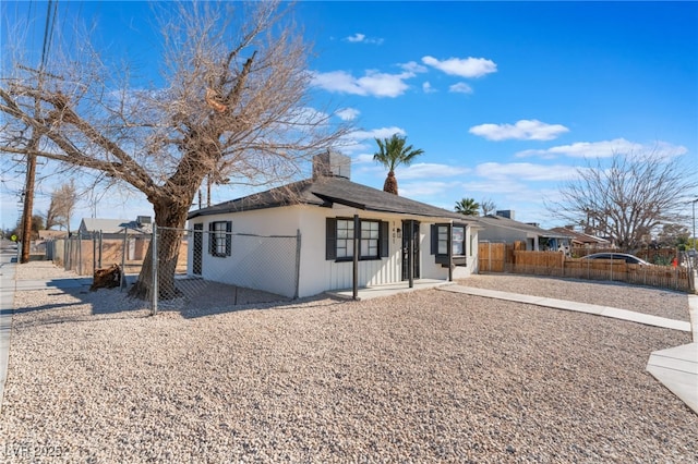 view of front of property with a chimney, stucco siding, and fence