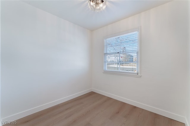 empty room with baseboards and light wood-type flooring