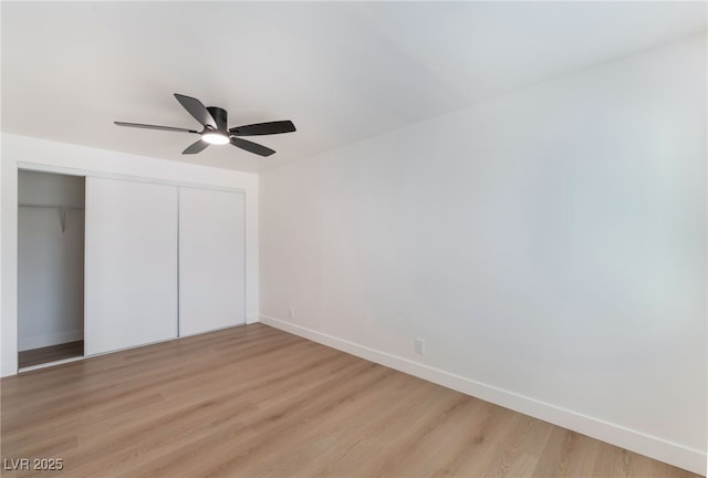 unfurnished bedroom featuring a closet, a ceiling fan, light wood-style flooring, and baseboards