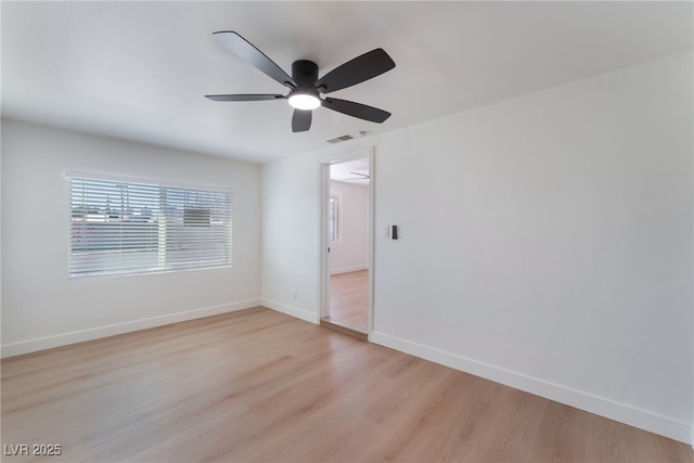 unfurnished room featuring a ceiling fan, baseboards, light wood-type flooring, and visible vents