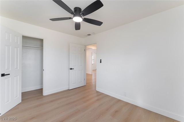 unfurnished bedroom featuring baseboards, a closet, light wood-style flooring, and a ceiling fan