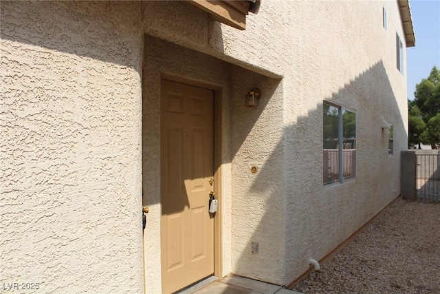 entrance to property featuring stucco siding