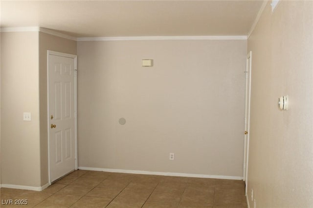 spare room with ornamental molding, light tile patterned flooring, and baseboards