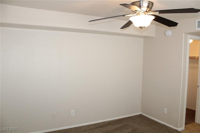 carpeted empty room featuring ceiling fan, baseboards, and a smoke detector