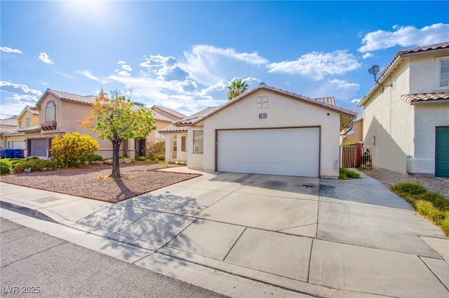6274 Elderberry Wine Ave, Las Vegas, NV 89142 - mediterranean / spanish home featuring concrete driveway, a tiled roof, stucco siding, and a garage