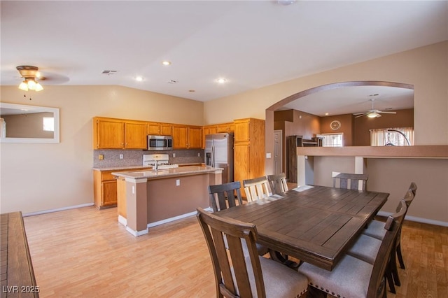 6274 Elderberry Wine Ave, Las Vegas, NV 89142 - dining space with visible vents, ceiling fan, vaulted ceiling, arched walkways, and light wood-type flooring