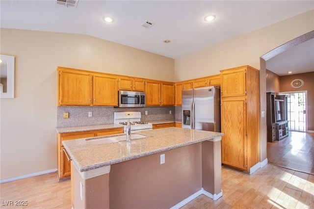 6274 Elderberry Wine Ave, Las Vegas, NV 89142 - kitchen with a sink, visible vents, light wood finished floors, arched walkways, and appliances with stainless steel finishes