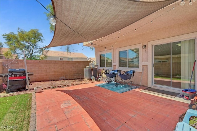 view of patio with area for grilling, fence, and central AC