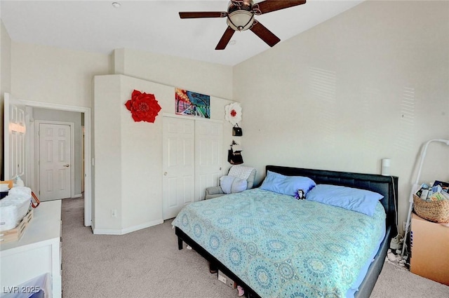 bedroom featuring light colored carpet, lofted ceiling, a closet, ceiling fan, and baseboards