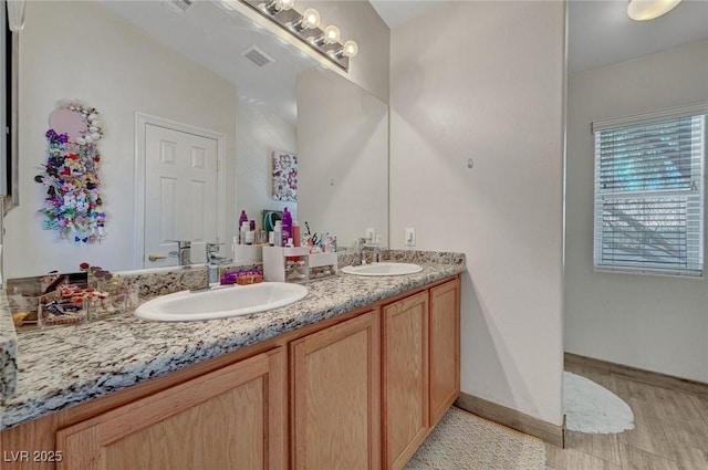 bathroom with double vanity and baseboards