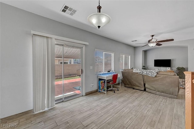 living area featuring plenty of natural light, a ceiling fan, and wood finished floors