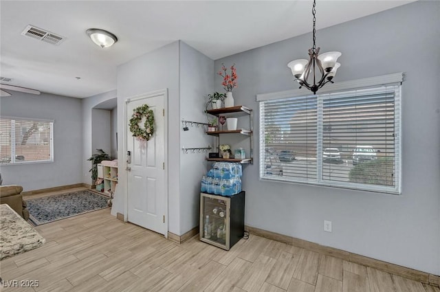dining area featuring a chandelier, wood finished floors, and baseboards