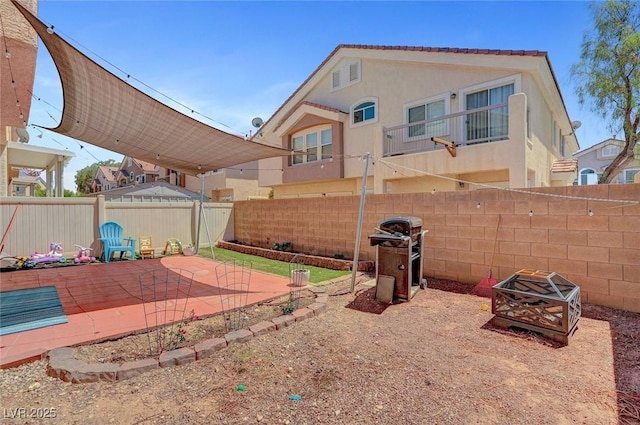 fenced backyard with a patio and an outdoor fire pit