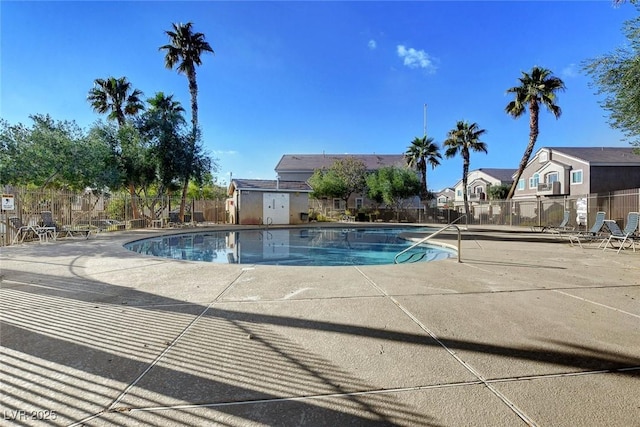 community pool with fence, a residential view, and a patio