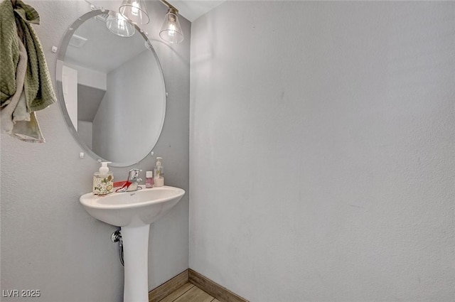 bathroom with wood finished floors and baseboards