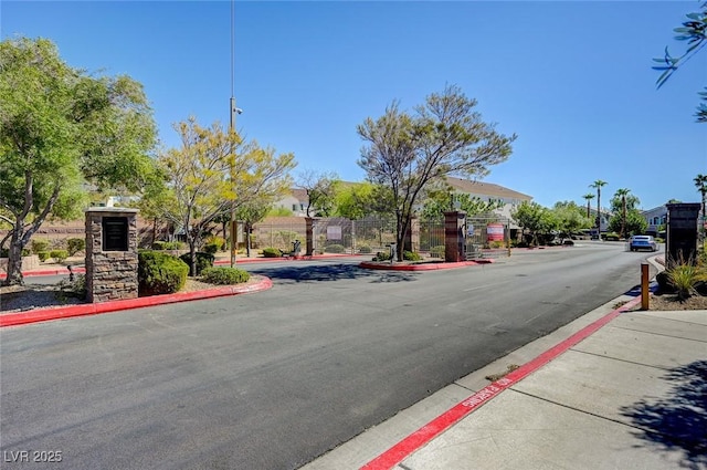 view of asphalt road featuring curbs and sidewalks