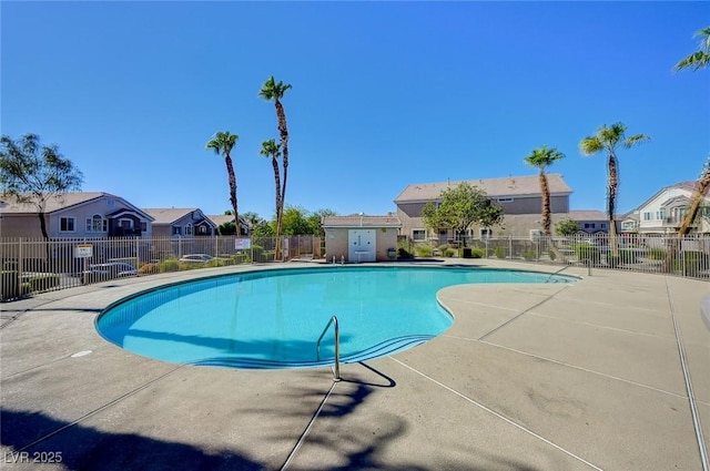 community pool with a residential view, fence, and a patio
