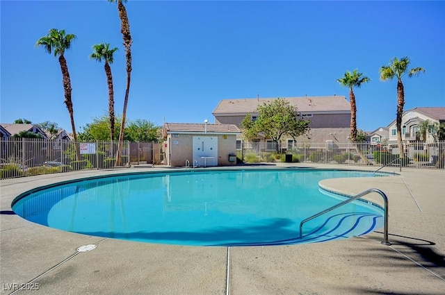community pool featuring fence, a residential view, and a patio area