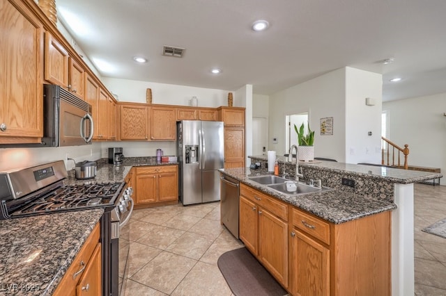 10294 Running Falls St, Las Vegas, NV 89178 - kitchen featuring appliances with stainless steel finishes, a sink, an island with sink, recessed lighting, and dark stone countertops