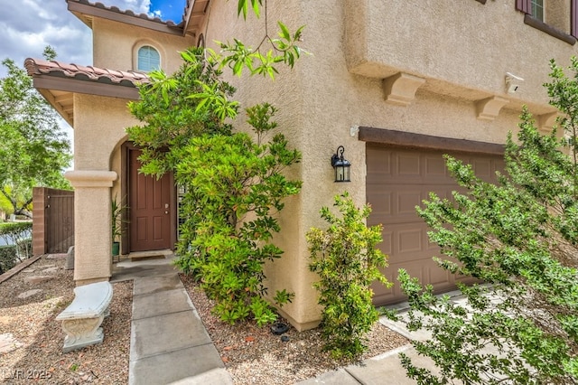10294 Running Falls St, Las Vegas, NV 89178 - view of exterior entry with stucco siding, a tile roof, and a garage