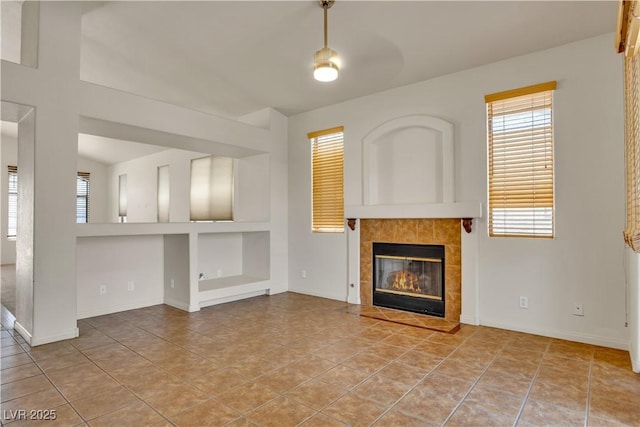 8940 Emery Lake St, Las Vegas, NV 89123 - unfurnished living room featuring a tile fireplace, built in shelves, and baseboards