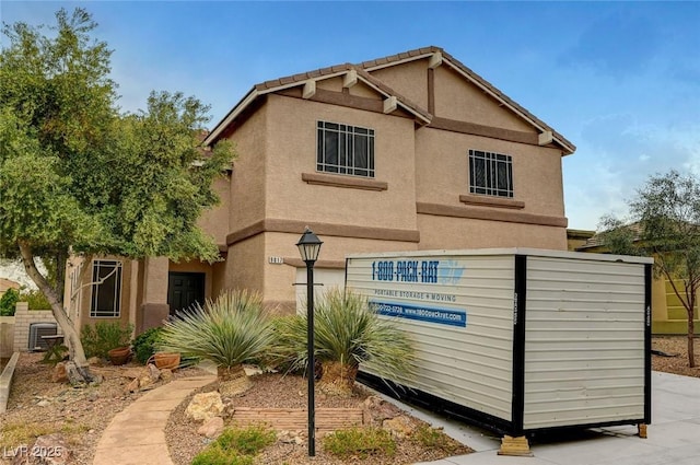 view of home's exterior with stucco siding and central AC