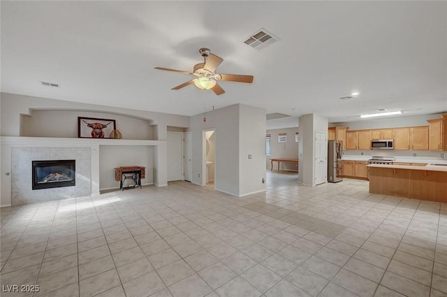 unfurnished living room with ceiling fan, light tile patterned flooring, a fireplace, baseboards, and recessed lighting