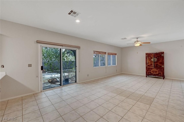 spare room with a ceiling fan, baseboards, and light tile patterned floors